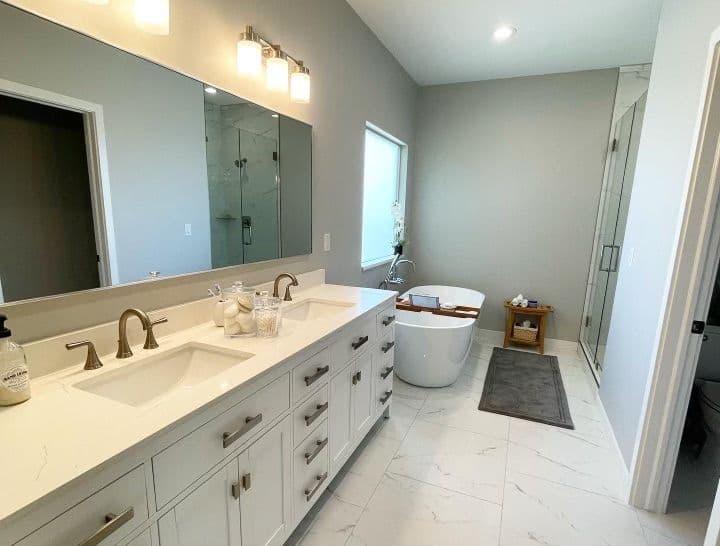 Modern bathroom featuring double vanity, freestanding bathtub, and large shower. Elegant design.