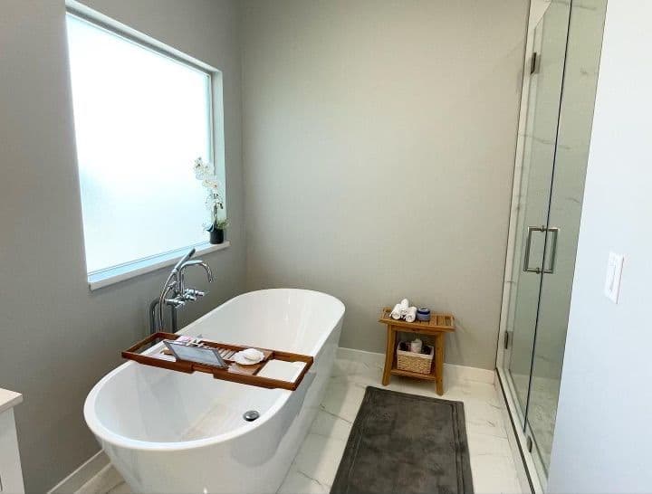 Modern bathroom featuring a freestanding tub, glass shower, and stylish wooden accents.